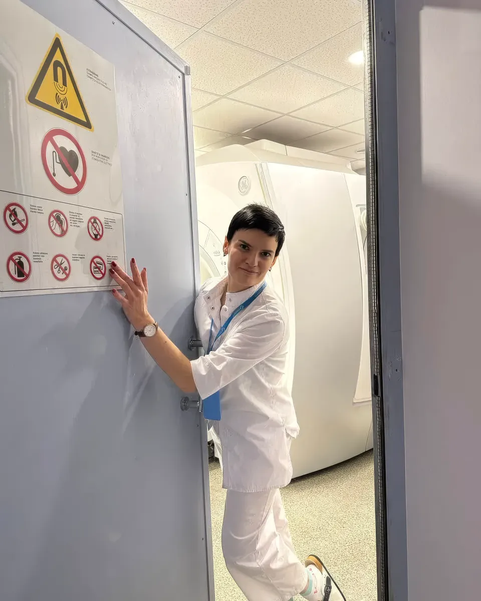Лікарка у білому халаті біля комп’ютерного томографа